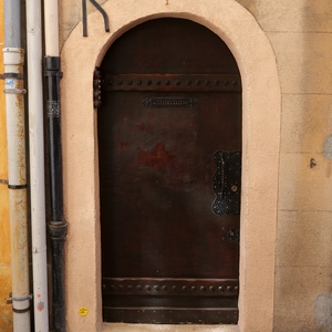 Jolie porte eb bois avec deux bandes cloutées, boite aux lettres et poignée travaillées entouré d'un mur jaune - France  - collection de photos clin d'oeil, catégorie portes